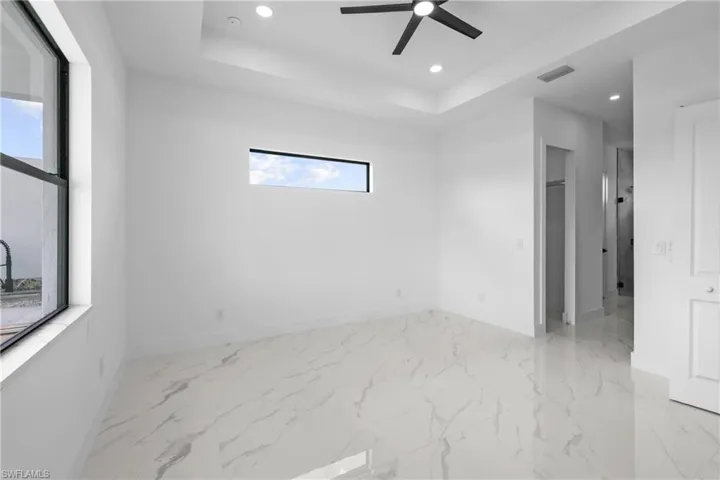 Unfurnished room with ceiling fan and a raised ceiling