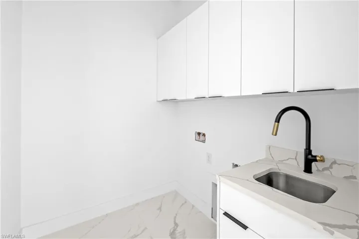 Washroom featuring cabinets, washer hookup, and sink