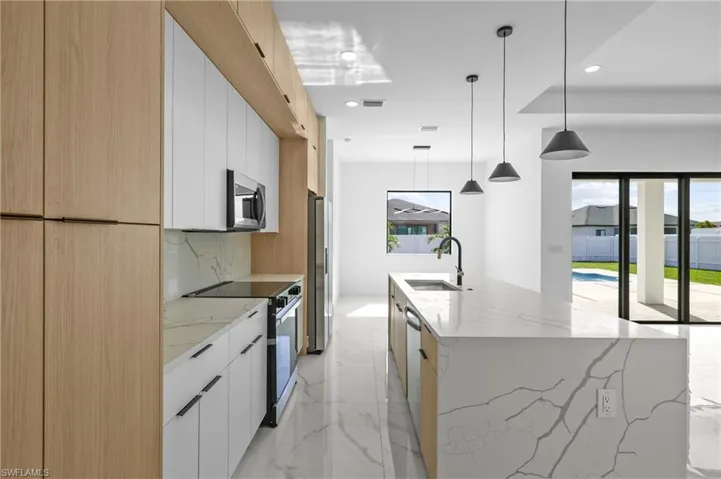 Kitchen featuring white cabinetry, appliances with stainless steel finishes, sink, and plenty of natural light