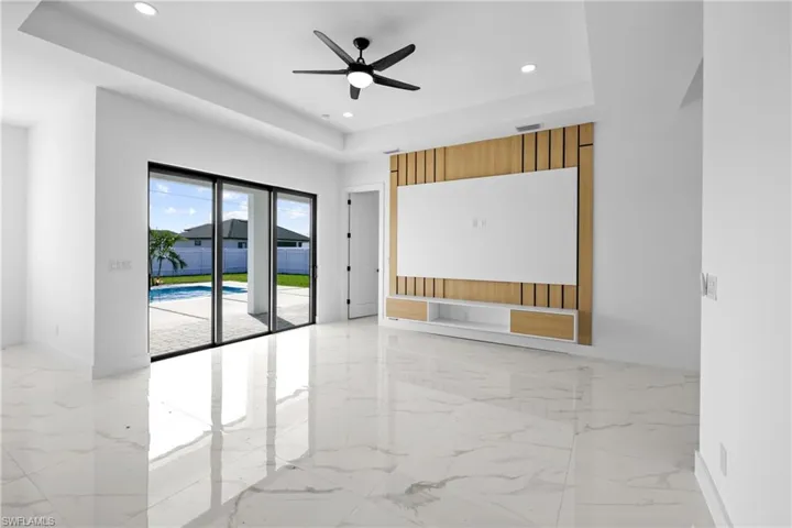 Unfurnished room with ceiling fan and a raised ceiling
