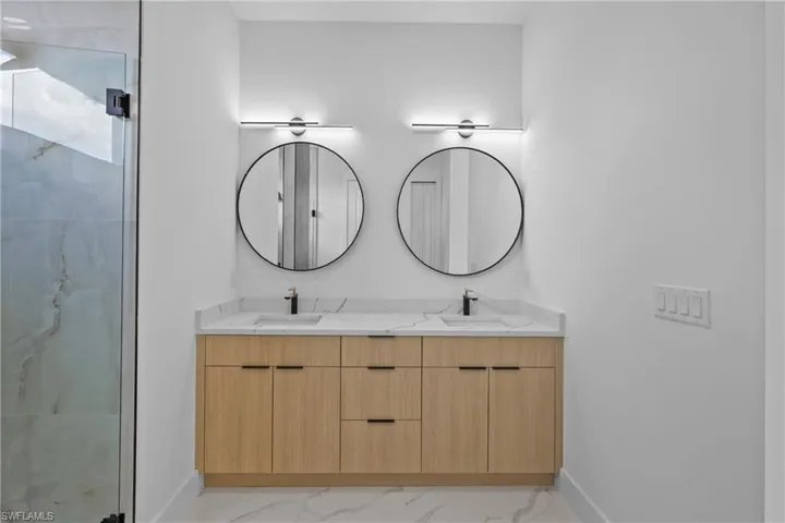 Bathroom with a shower with shower door and vanity