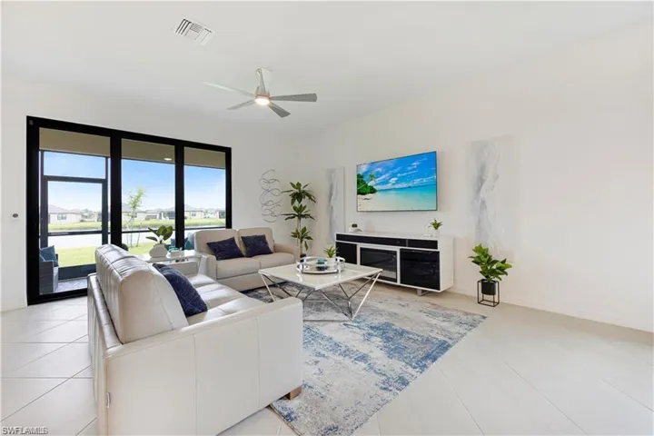 Living area with a ceiling fan and light tile patterned floors