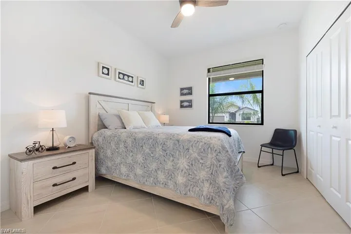 Bedroom featuring ceiling fan, light tile patterned floors, and a closet
