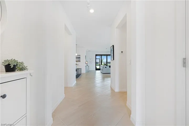 Hallway with baseboards and light tile patterned floors