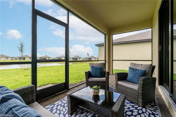 Sunroom with a residential view, an outdoor lounge area, and a water view