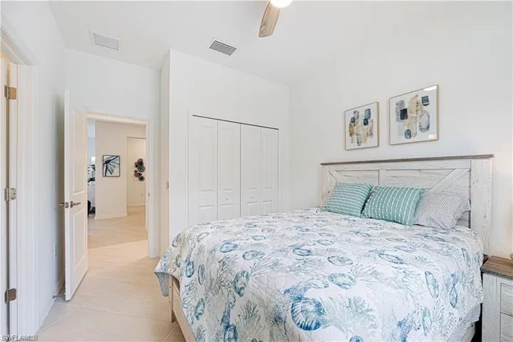 Bedroom featuring a closet, ceiling fan, and light tile patterned floors