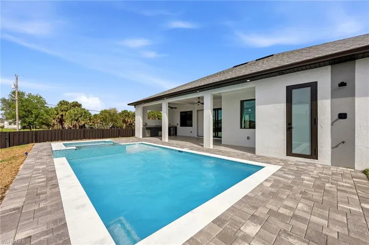 Integrated pool / spa featuring a patio area and a fenced backyard