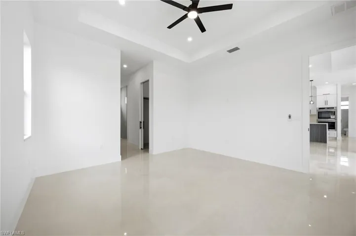 Unfurnished room featuring a raised ceiling, recessed lighting, and a ceiling fan