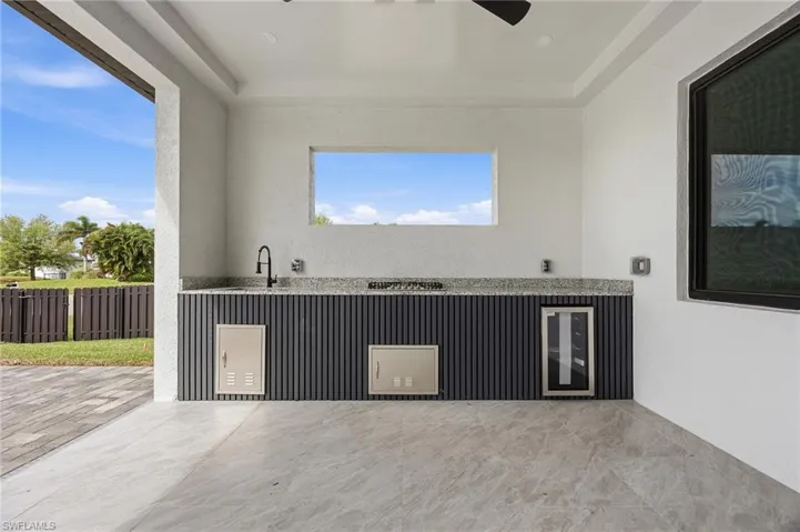 View of patio / terrace featuring beverage cooler and ceiling fan