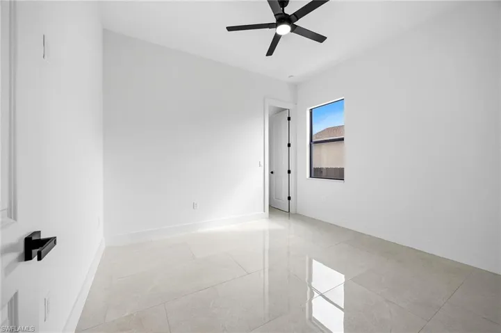 Unfurnished room featuring a ceiling fan and baseboards