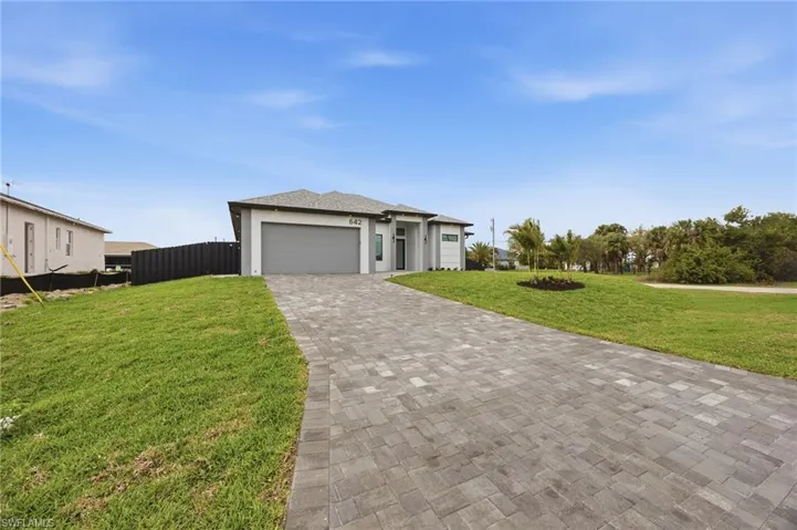 Prairie-style home featuring decorative driveway, an attached garage, and stucco siding