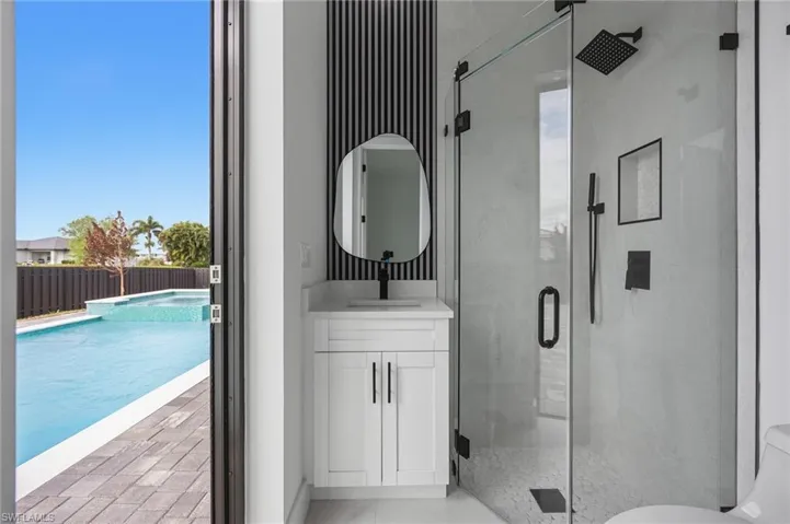 Bathroom with vanity and a marble finish shower