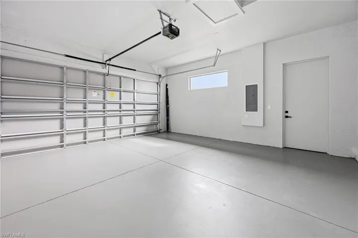 Garage with electric panel and a garage door opener