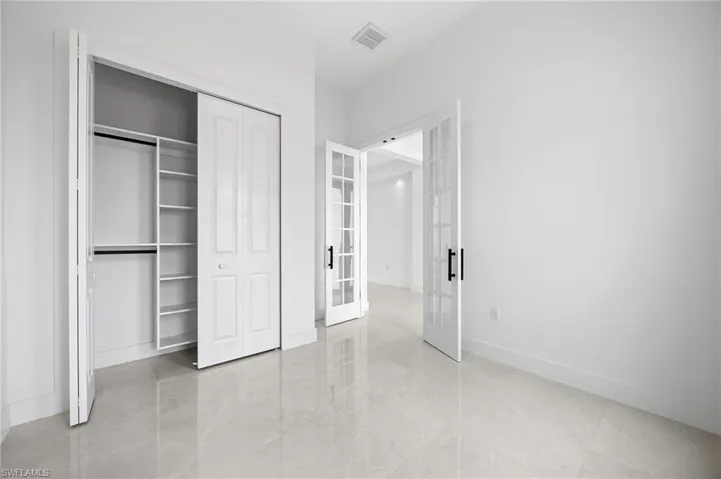 Unfurnished bedroom featuring a closet and french doors