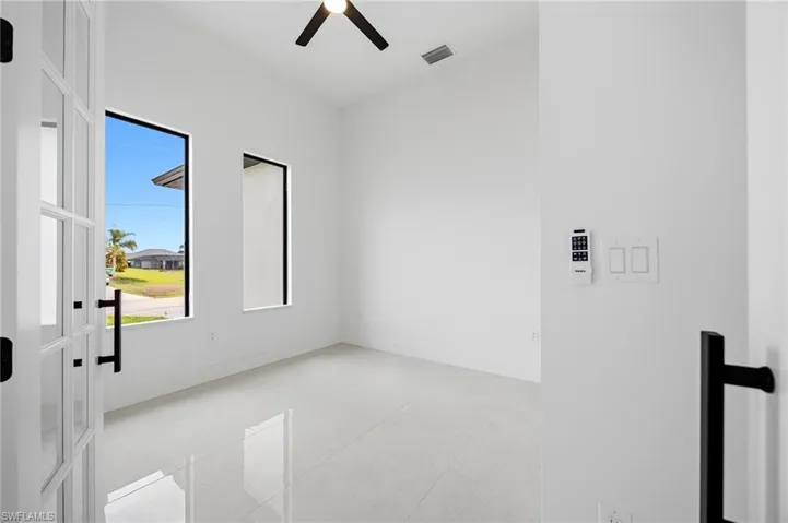 Spare room with a ceiling fan and light tile patterned flooring
