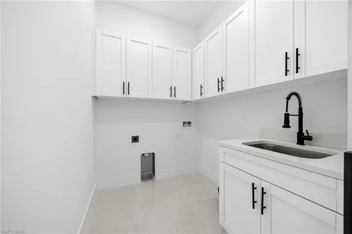 Laundry room featuring washer hookup, cabinet space, hookup for an electric dryer, and light tile patterned flooring