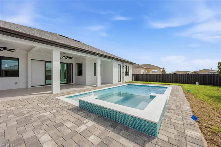 Combined pool / hot tub featuring a patio and a fenced backyard