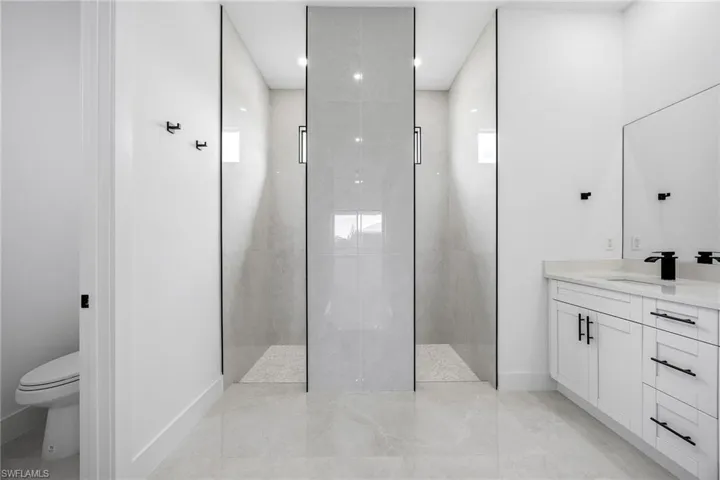 Bathroom with walk in shower, vanity, and recessed lighting