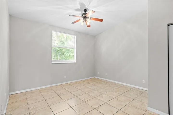 Spare room featuring baseboards, a ceiling fan, and light tile patterned flooring