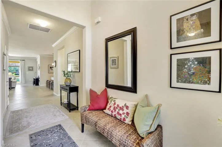 Hallway featuring crown molding and light tile patterned floors