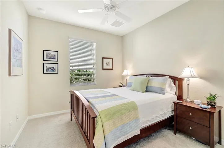 Carpeted bedroom featuring ceiling fan