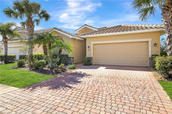 Mediterranean / spanish home with a garage and a front yard