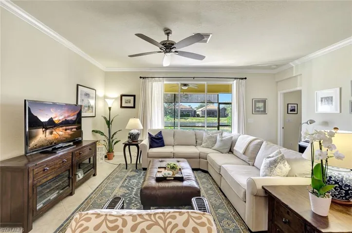 Living room with light tile patterned floors and ornamental molding