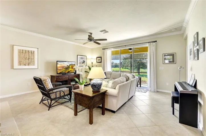Tiled living room featuring ornamental molding and ceiling fan