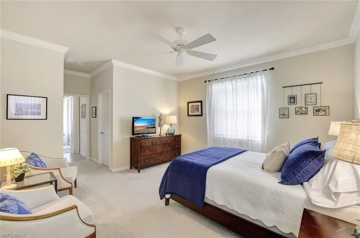 Carpeted bedroom featuring crown molding and ceiling fan
