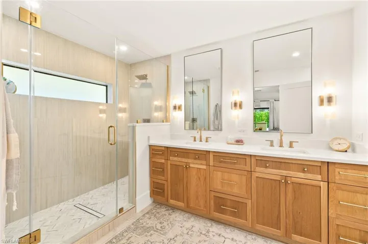 Full bath with a shower stall and double vanity