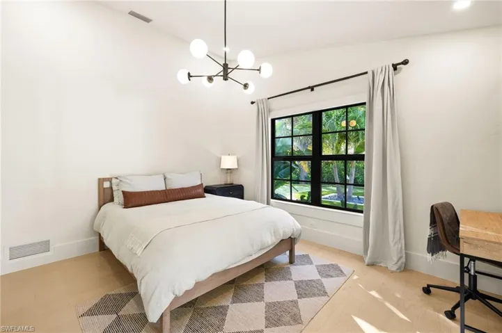 Bedroom with a chandelier and light wood-style flooring