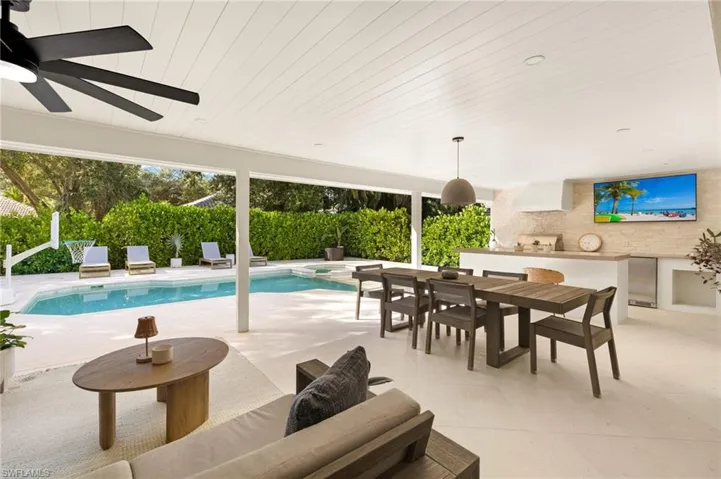 View of pool with area for grilling, a patio area, outdoor dining space, a ceiling fan, and a pool with connected hot tub