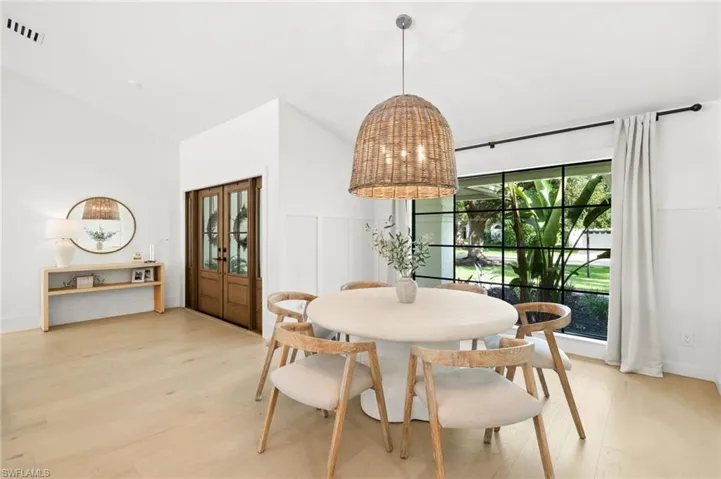 Dining room featuring light wood-style flooring and vaulted ceiling