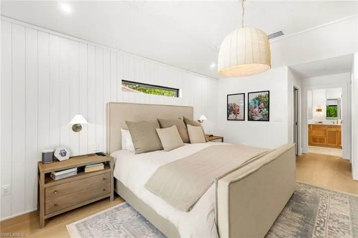 Bedroom with wood finished floors, recessed lighting, and ensuite bathroom