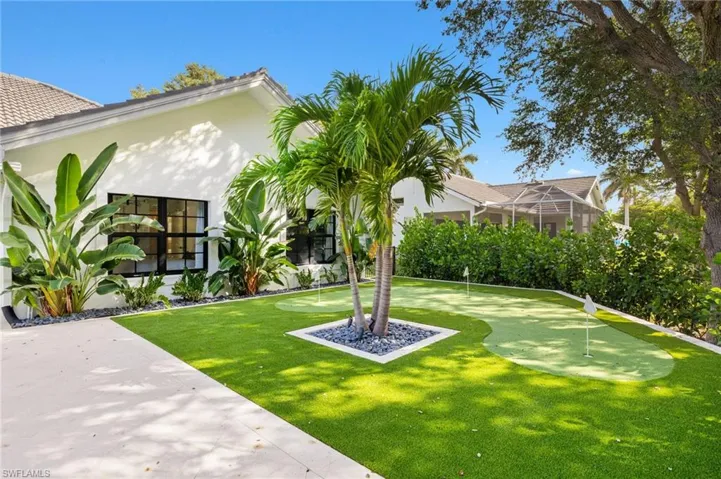 View of yard with an area to practice putting and a lanai