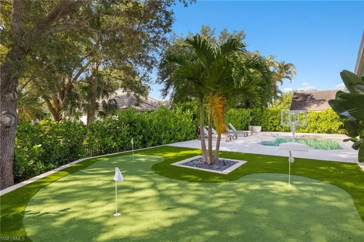 Surrounding community featuring an area to practice putting, a patio, and a pool