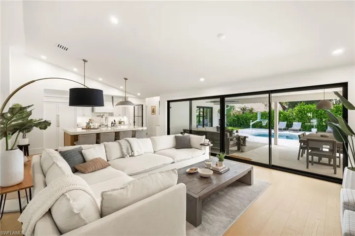 Living room with recessed lighting, light wood-type flooring, and vaulted ceiling