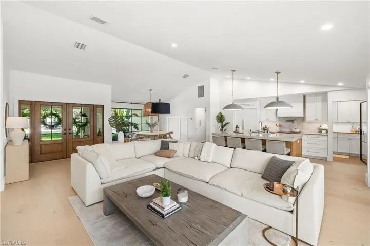 Living area with light wood-style flooring, french doors, recessed lighting, and high vaulted ceiling
