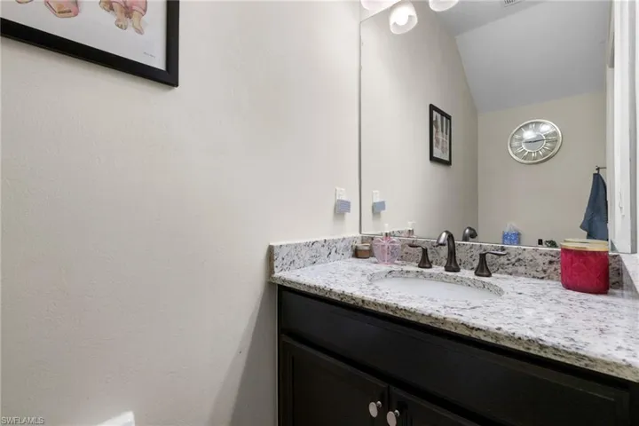 Bathroom featuring vanity and vaulted ceiling