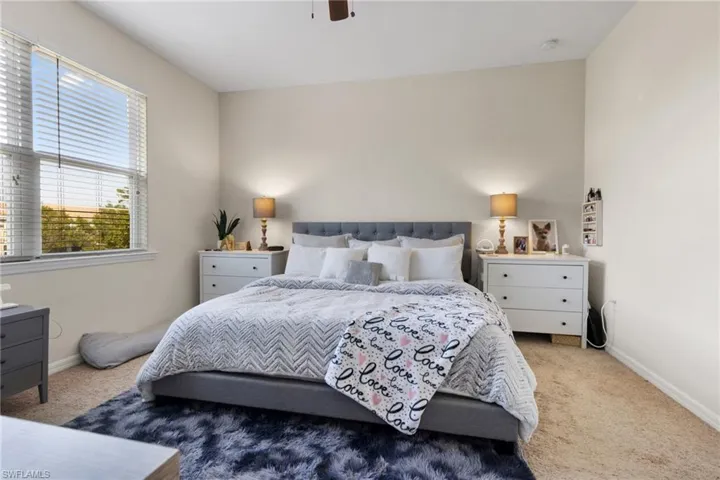 Bedroom with ceiling fan and light carpet
