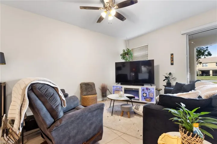Living room featuring ceiling fan and light tile patterned floors