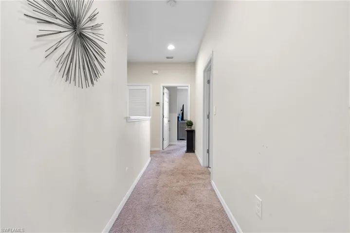 Hall featuring light colored carpet