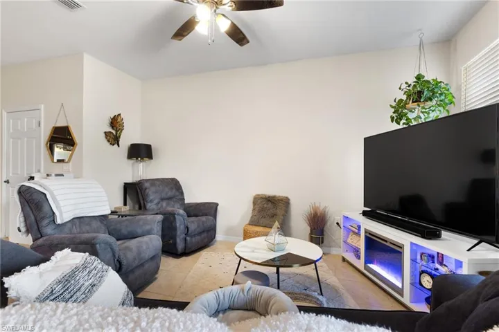 Living room featuring ceiling fan and tile patterned flooring