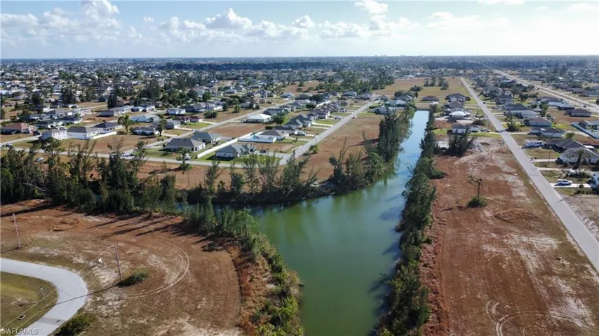 Birds eye view of property with a water view