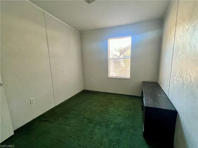 Unfurnished room with dark carpet