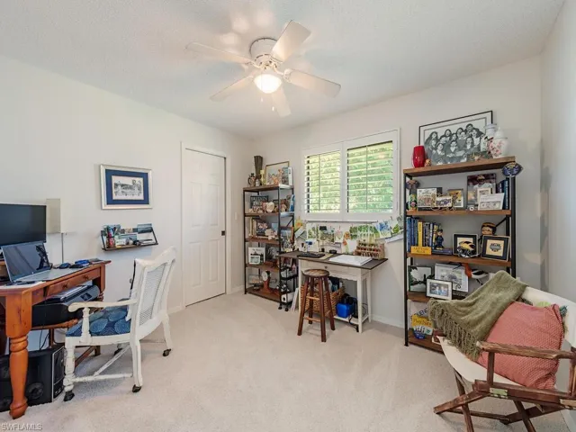 Office space featuring baseboards, carpet floors, a textured ceiling, and a ceiling fan