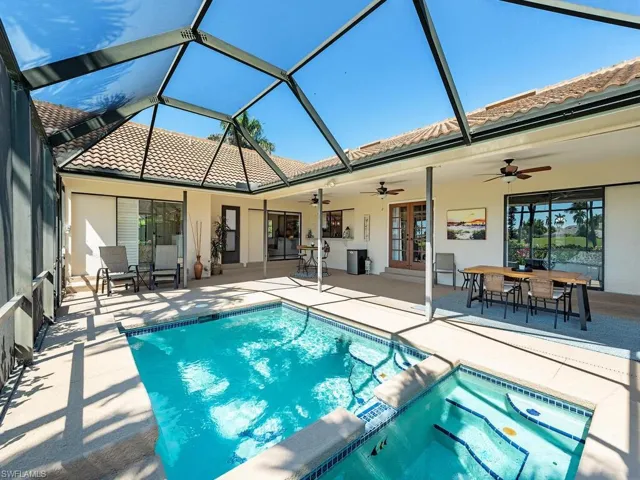 View of swimming pool with a pool with connected hot tub, a patio, french doors, and a ceiling fan