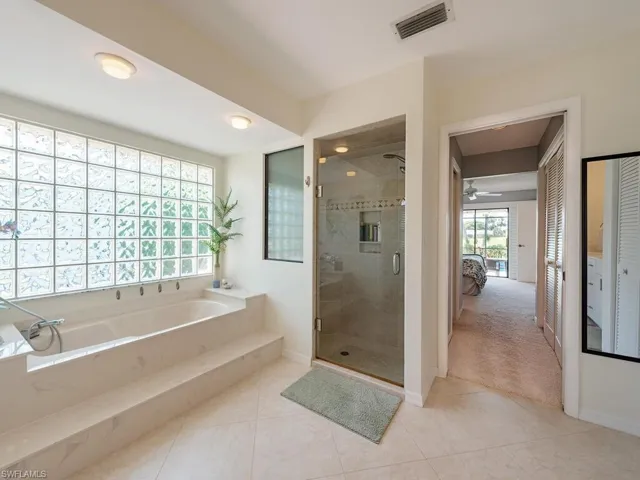 Ensuite bathroom with tile patterned floors, a stall shower, ensuite bath, a garden tub, and visible vents