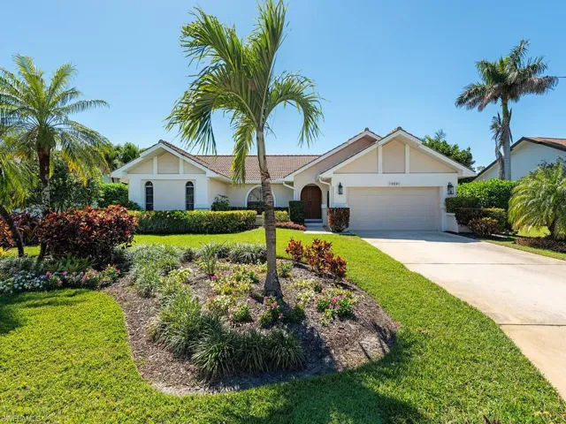 View of front of property with a front lawn, concrete driveway, stucco siding, and an attached garage