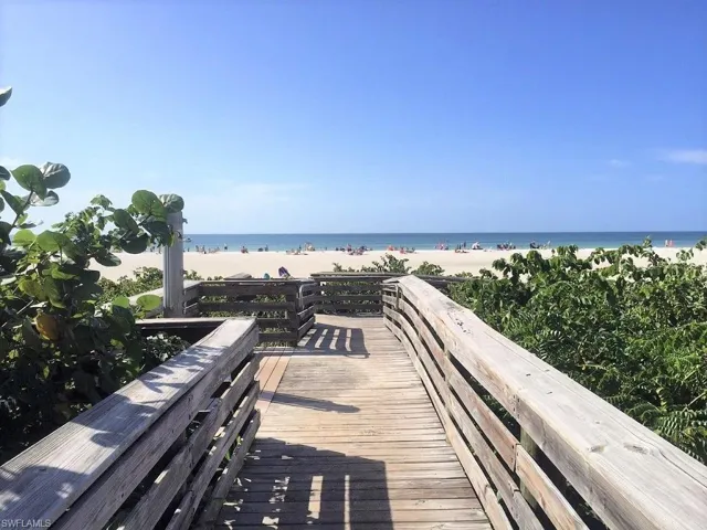 View of property's community featuring a water view and a beach view